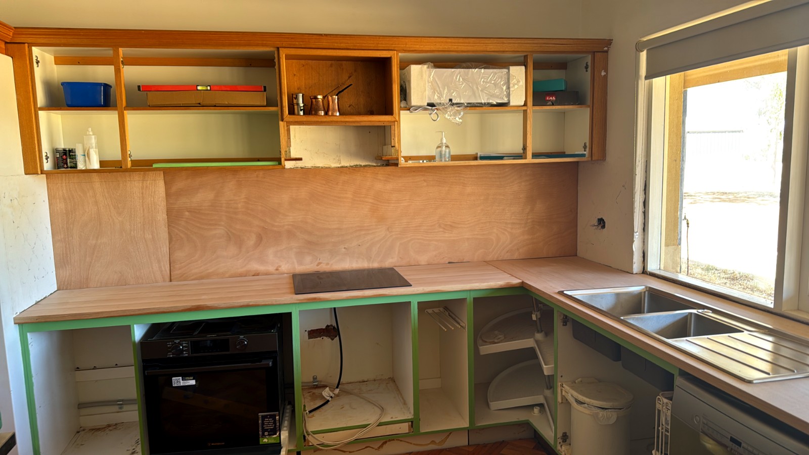 Kitchen mid-renovation, new benchtops and plywood splashback in place
