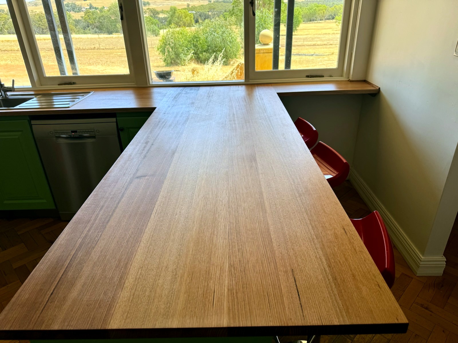 Renovated kitchen, solid timber breakfast bar with red stools
